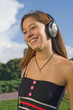 Beautiful Girl Listening Music with headphones Outdoors Beautiful Girl Listening Music with headphones Outdoors