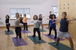 Teacher guides student in yoga class