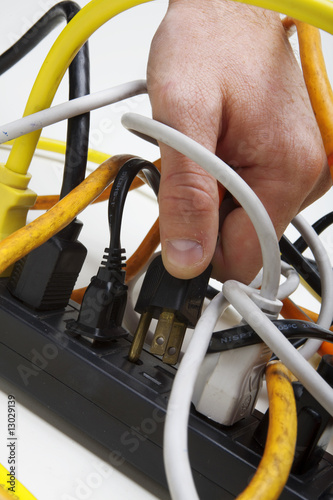 Photo: Plugging a cord into a tangled surge protector. Plugging a cord into a tangled surge protector.