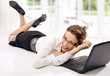 Happy young businesswoman with laptop on the floor