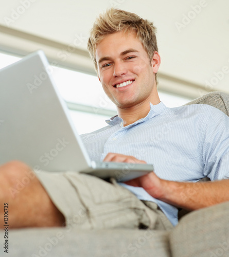 Foto: A confident young man working on a laptop A confident young man working on a laptop