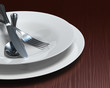 Illustration: Clean white dishes & cutlery on dark woodgrain table Clean white dishes & cutlery on dark woodgrain table