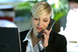 femme au téléphone devant un ordinateur de bureau