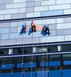 Three men repairing wall of the skyscraper Three men repairing wall of the skyscraper