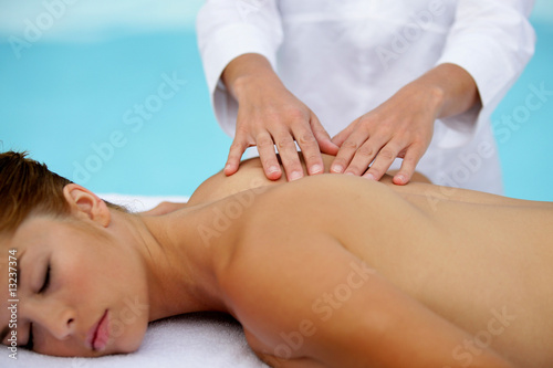 Photo : belle femme allongée sur son ventre se faisant masser le dos belle femme allongée sur son ventre se faisant masser le dos