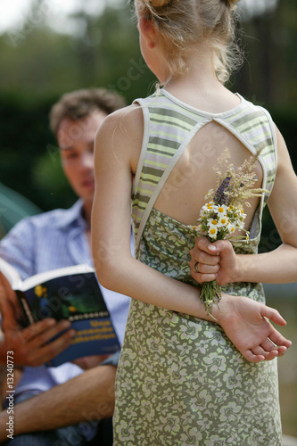 Photo: fille cachant des fleurs derrière son dos fille cachant des fleurs derrière son dos