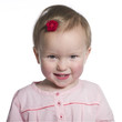 Happy toddler smiling in pink dress.