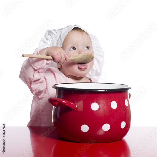 Foto: Toddler pretending to cook with a big red pot. Toddler pretending to cook with a big red pot.
