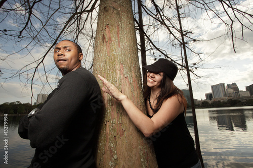Photo: Woman sneaking up on a man in the park Woman sneaking up on a man in the park