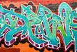 Graffiti detail on the textured brick wall