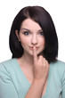 Attractive brunette girl with finger on lips on white