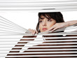 young woman looks through jalousie