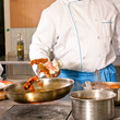 Chef hands with frying pan on professional kitchen