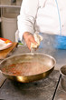 Chef hands with frying pan on professional kitchen