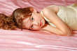 Foto: Beautiful little girl on linen in bed Beautiful little girl on linen in bed