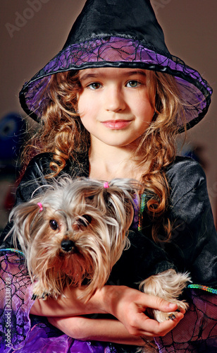 Foto: Liitle girl in witch costume with dog Liitle girl in witch costume with dog