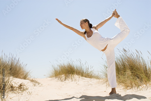 Frau macht Yoga im Sand
