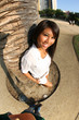 Beautiful Asian girl leaning to palm tree