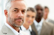 Closeup of a senior business man with his colleagues standing