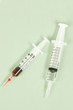 Foto: Two syringes on green background Two syringes on green background