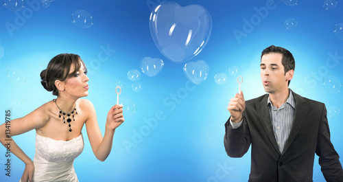 Photo: Wedding couple blowing heart shaped romantic soap bubbles Wedding couple blowing heart shaped romantic soap bubbles