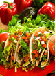 Plate of freshly prepared ground beef tacos, with tomato, cheese