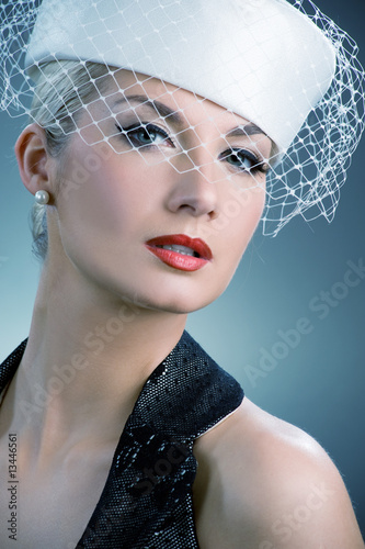 Photo: Beautiful young woman in white hat with net veil. Retro portrait Beautiful young woman in white hat with net veil. Retro portrait