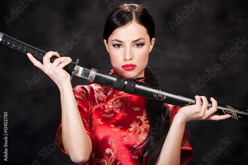 Photo: Pretty woman holding katana weapon Pretty woman holding katana weapon