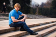 Blond man sitting outdoors