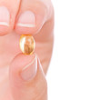 Hand holding a capsule or pill close up. Hand holding a capsule or pill close up.