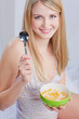 blond girl sitting on bed and holding spoon and morning meal
