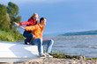 Young love Couple sit on boat on coast of river Young love Couple sit on boat on coast of river