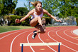 Photo: Athletic girl hurdling at the track Athletic girl hurdling at the track