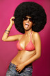Beautiful woman with huge afro haircut on pink