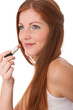Body care series - Beautiful young woman applying lipstick