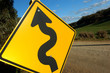 Image : A windy road is warned by a big yellow sign