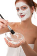 Body care series - Young woman applying white facial mask
