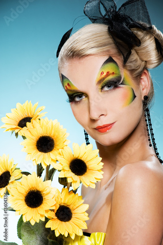 Photo: Young beauty with butterfly face-art and bouquet of sunflowers Young beauty with butterfly face-art and bouquet of sunflowers