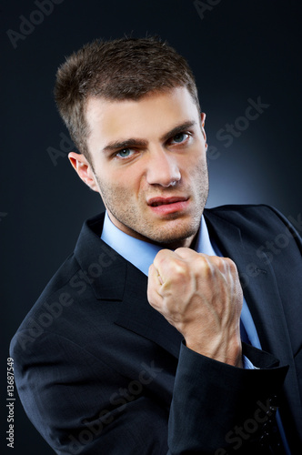 Photo: Portrait of business man isolated on dark background Portrait of business man isolated on dark background