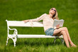 Blond young woman sitting on bench with book