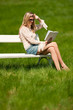Attractive blond woman sitting on white bench