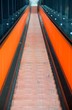 Blick zum Endpunkt einer orangenen Rolltreppe