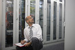 Mature man checking computers in server room