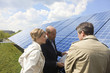 Photo: Three mature adults reading plans laid on solar panels in Munich, Bavaria, Germany Three mature adults reading plans laid on solar panels in Munich, Bavaria, Germany