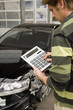 Insurance adjuster assessing damage to car