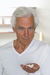 Senior man holding handful of pills