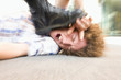 Photo: Young man lying on ground being stepped on by someone wearing black boot Young man lying on ground being stepped on by someone wearing black boot