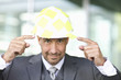 Portrait of mature man pointing at hardhat with note papers stuck to it