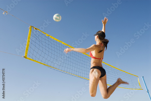Junge Frau spielt Volleyball am Strand Junge Frau spielt Volleyball am Strand