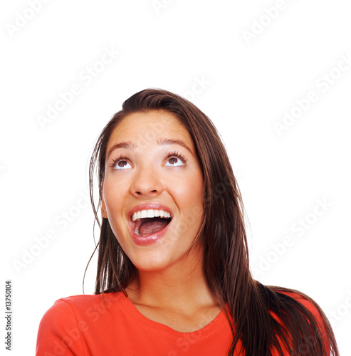 Happy young lady looking upwards over white.